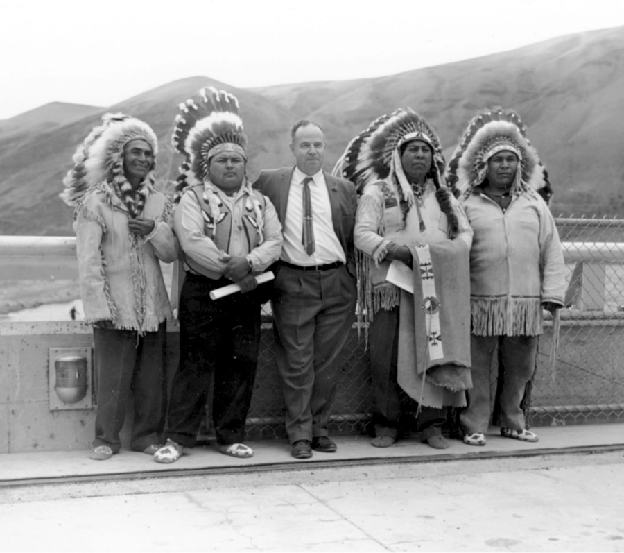 Wanapum Bg Historical black and white photo of Wanapum in regalia standing with a man in a business suit.